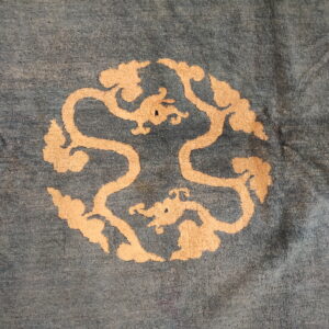 Slate blue rug with a light beige circular medallion featuring stylized dragons and swirling clouds.