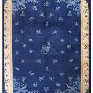 Indigo rug with light blue symbols, framed by a wide tan border featuring dark blue landscape designs.