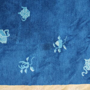 Deep blue high-pile rug with scattered light blue ornamental designs and a visible pale yellow border.