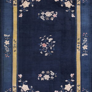 Dark blue rug with floral vines, cream and pink motifs, and a wide mustard yellow inner border.