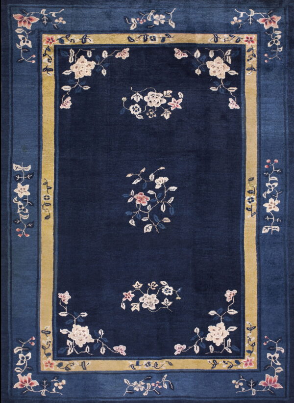 Dark blue rug with floral vines, cream and pink motifs, and a wide mustard yellow inner border.
