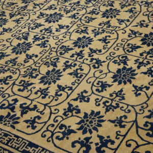 Gold and navy rug showcasing an all-over repeating floral and vine geometric lattice pattern with a border detail.