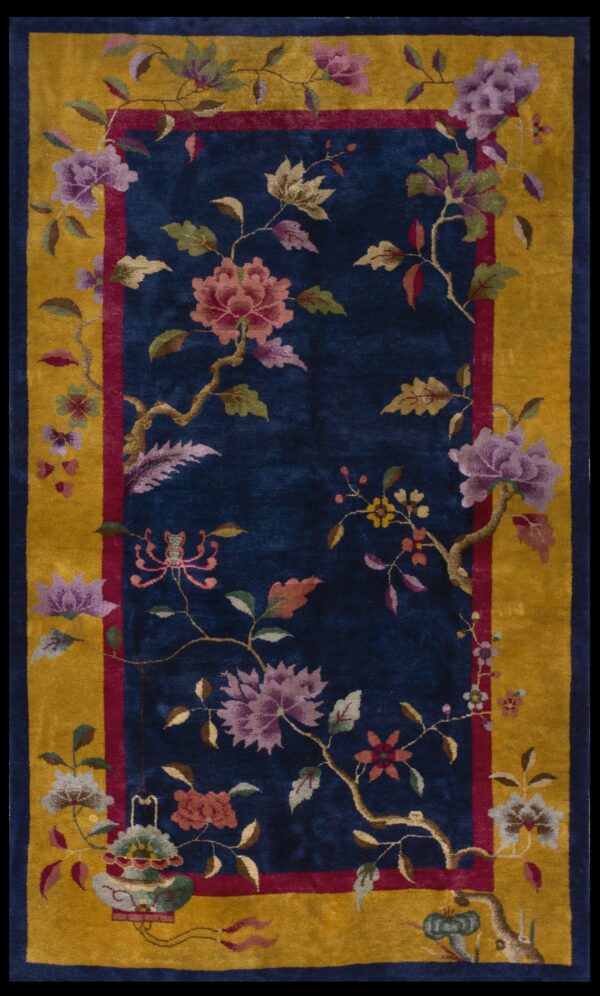 Velvety indigo rug with an elaborate floral design and a wide golden yellow border.