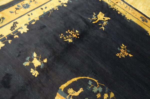 High-pile rug featuring a dark field and golden border with floral and avian designs.