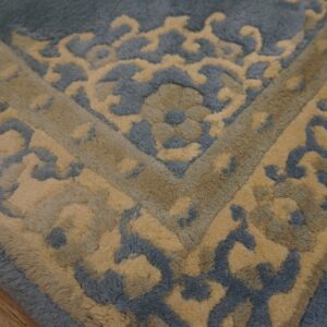 High-pile blue and tan rug with a plush ornate pattern on rustic wood flooring.