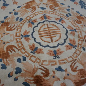 Ornate cream rug featuring a central medallion, rust-orange birds, blue leaves, and geometric motifs.