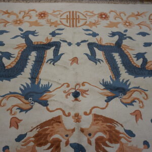 Cream rug with mirrored blue dragons, orange floral motifs, and symbolic designs.
