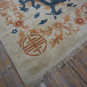 Light beige rug featuring a blue dragon, orange flowers, and Shou symbols on rustic wooden floors.