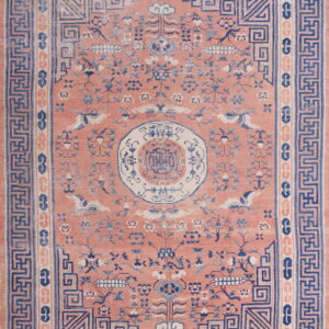 Pink rug with low pile features a detailed blue and cream stylized floral and geometric design.