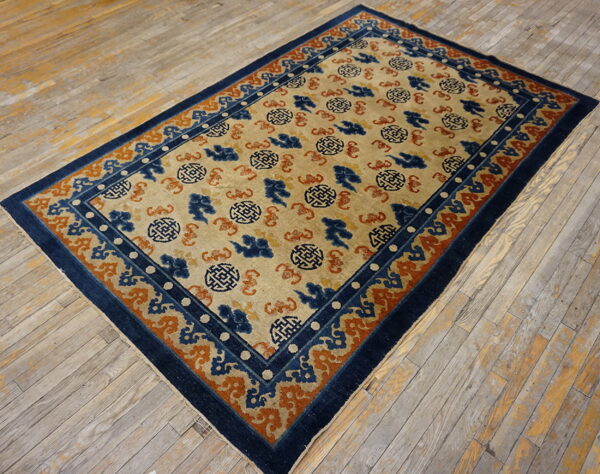Beige rug featuring blue and orange medallion and cloud patterns, surrounded by a navy border.