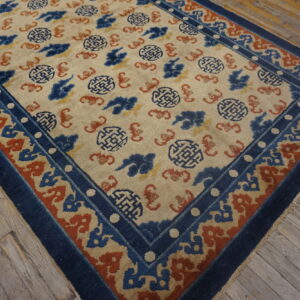 Cream rug featuring blue and terracotta geometric and cloud motifs rests on rustic wood floors.