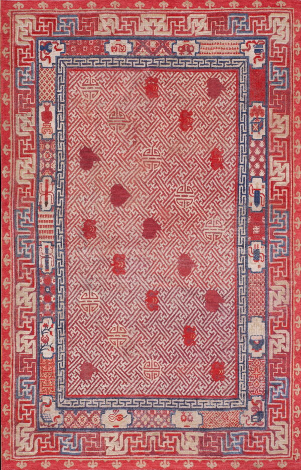Low-pile rug with red and tan geometric patterns, detailed borders, and blue accents.