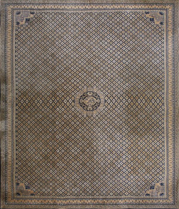 Low-pile rug with navy and tan geometric motifs, a dense field design, and elaborate borders.