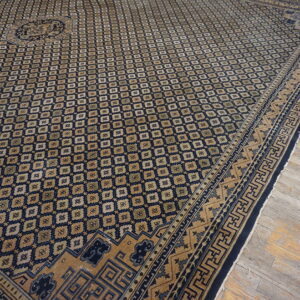 Geometric navy blue and tan rug with a central medallion rests on worn wood planks.