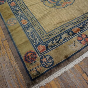 Geometric khaki rug with wide olive and cobalt blue borders featuring floral medallions on distressed wood floors.