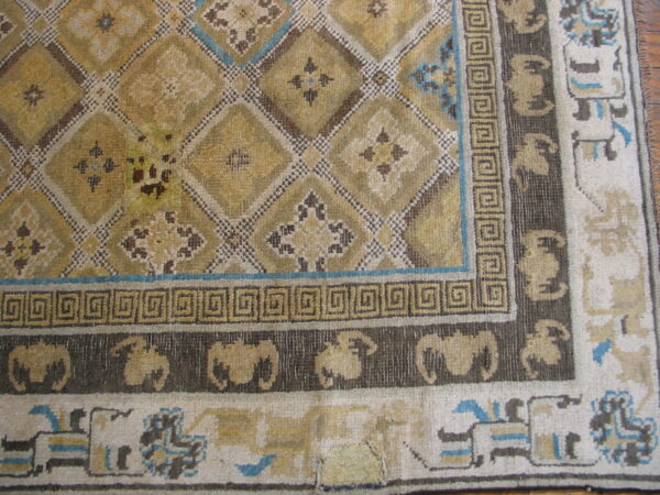 Gold, brown, and blue patterned rug showing a diamond field and repeating animal border designs.