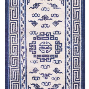 Cream and blue rug with geometric key borders and stylized central cloud motifs.
