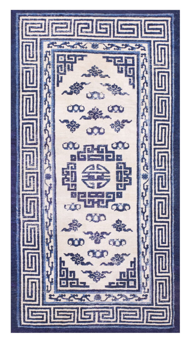 Cream and blue rug with geometric key borders and stylized central cloud motifs.