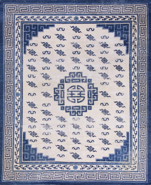 High-contrast blue and cream rug with a geometric border framing ruyi cloud patterns and a shou medallion.