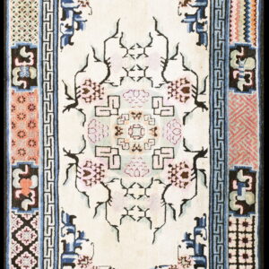 Cream rug with a stylized pink floral medallion and geometric patterns framed by complex blue, black, and coral borders.