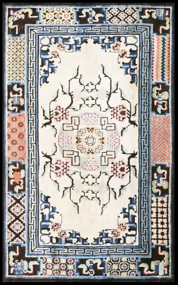 Cream rug with a stylized pink floral medallion and geometric patterns framed by complex blue, black, and coral borders.