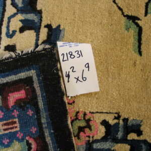 A close-up shows a tan patterned rug next to a folded edge with geometric blue and pink designs.