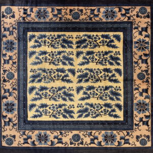 Square rug featuring dark blue floral motifs on a light gold field with elaborate patterned borders.