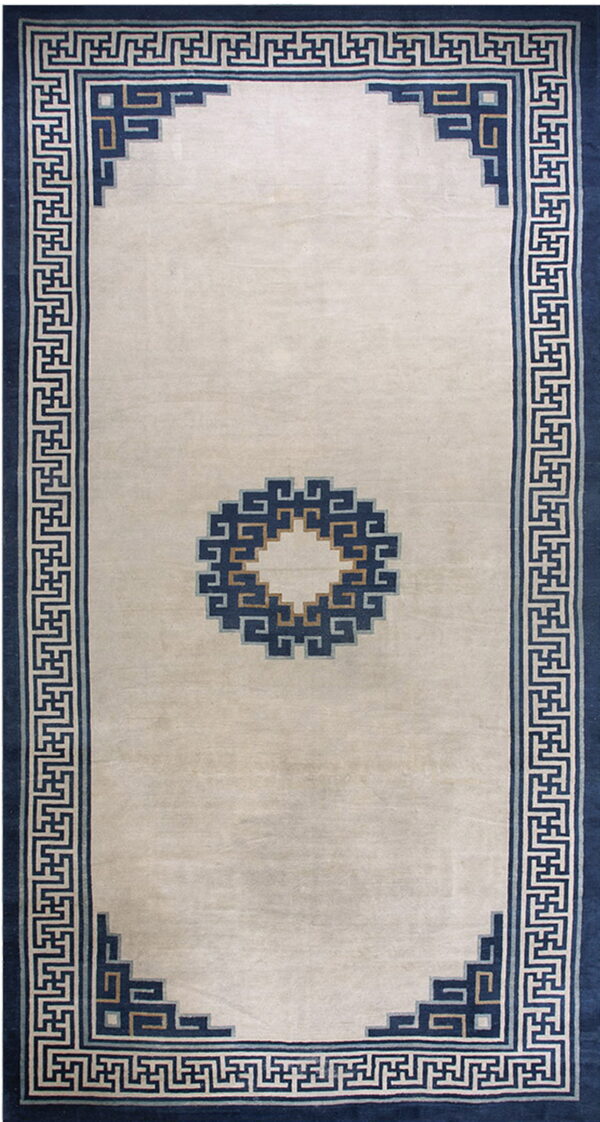 Cream rug with a navy geometric key border surrounding a plain field and central stepped medallion.