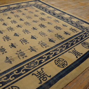 Beige rug featuring a repetitive blue motif field and thick ornamental borders on rustic wood flooring.