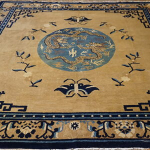 Golden tan rug with a navy border and a light blue medallion featuring two detailed dragons.