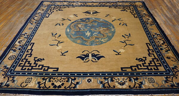 Golden tan rug with a navy border and a light blue medallion featuring two detailed dragons.