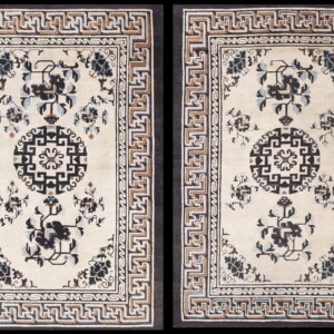 Pair of cream rugs with dark floral motifs, black medallions, and geometric meander borders.