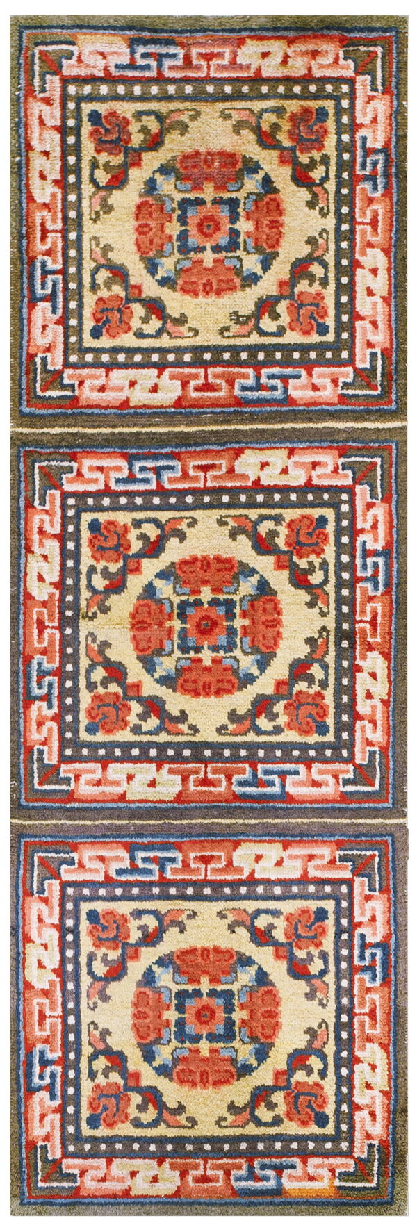 Geometric runner rug with repeated medallions and greek key borders in cream, red, blue, and olive.