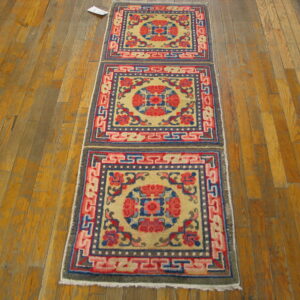 Colorful runner rug displaying repeated red, blue, and yellow medallions with geometric borders on wood flooring.