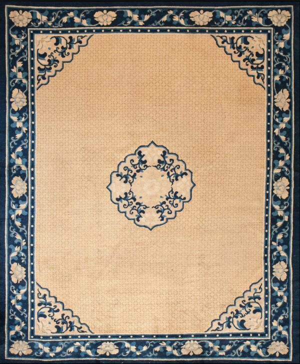 A beige rug with a detailed navy and blue floral and vine border and a matching central medallion.