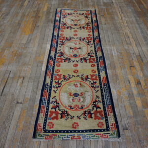 Light yellow runner rug featuring red and blue medallions sits centered on distressed gray wood planks.