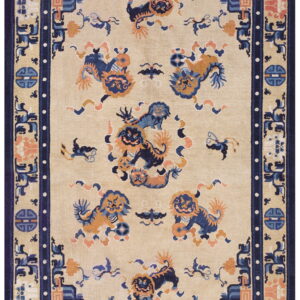 Low-pile rug with a beige field, navy border, and colorful blue and orange guardian lion designs.