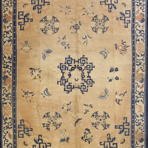 Peach and navy blue rug featuring a central geometric medallion and scattered floral sprays on a soft pile.