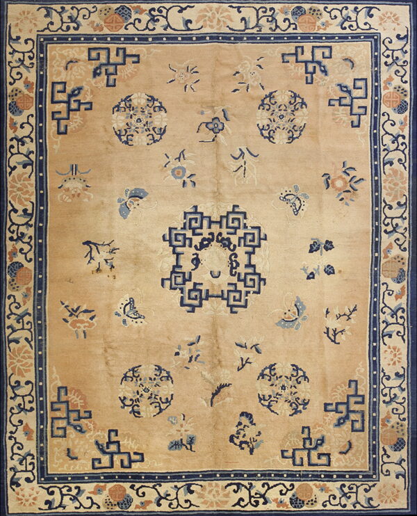 Peach and navy blue rug featuring a central geometric medallion and scattered floral sprays on a soft pile.
