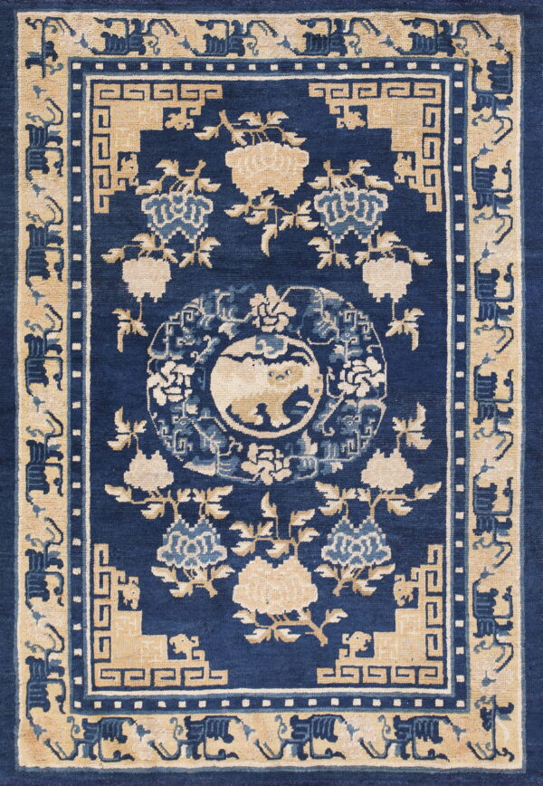 Dense blue rug with beige borders, traditional floral pattern, geometric motifs, and a central medallion design.