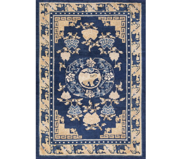 Deep blue rug with tan and light blue floral designs and a central animal medallion.