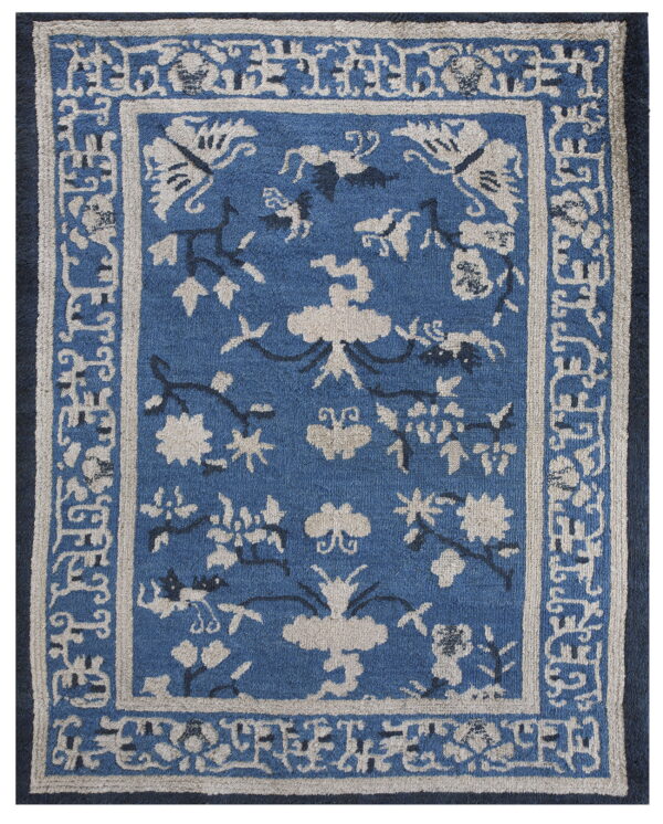 Medium-pile blue rug featuring beige and dark blue stylized floral and vine patterns within intricate borders.