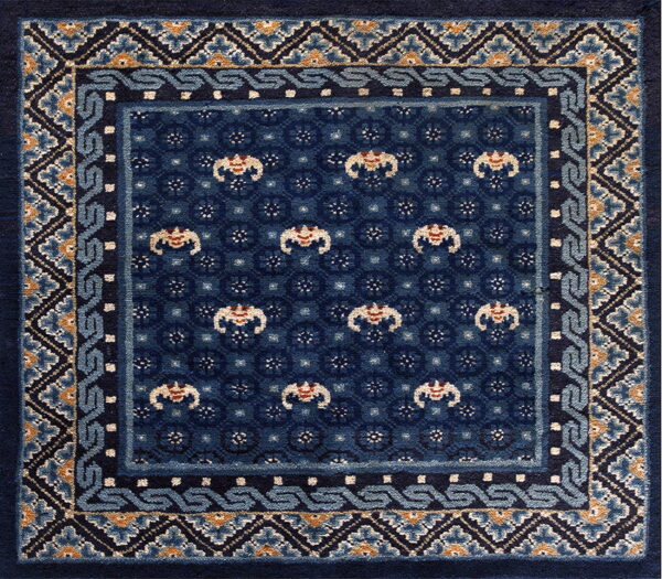 A deep blue rug featuring highly detailed geometric and floral patterns with light blue and tan accents.