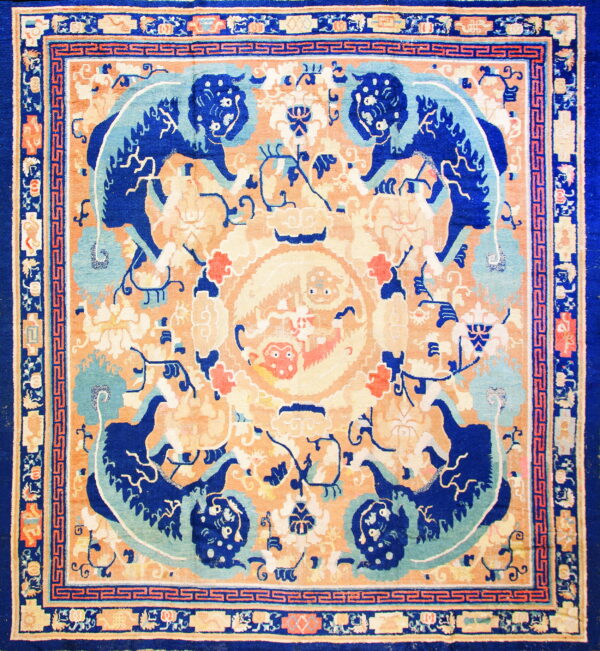 Blue and peach rug with a central medallion flanked by large stylized dark blue figures.