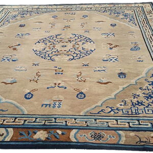 Beige field rug with a detailed blue central medallion, small scattered motifs, and layered blue and brown borders.
