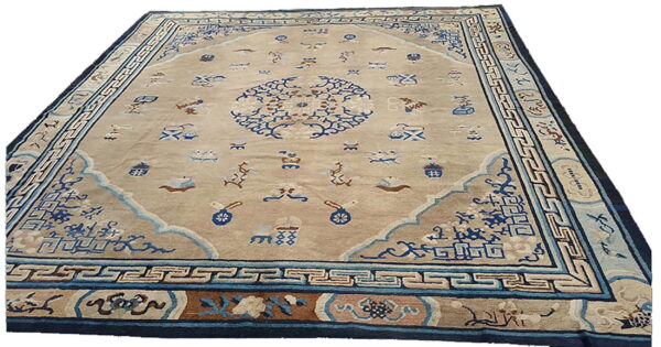 Beige field rug with a detailed blue central medallion, small scattered motifs, and layered blue and brown borders.