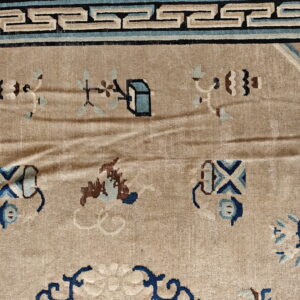 Beige rug detail shows a dark blue geometric border and tan field with scattered blue and brown designs.