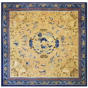 Oriental style rug featuring a golden yellow field, navy border, and central dark blue stylized animal designs.