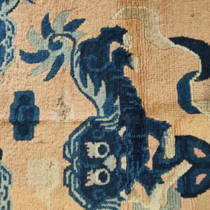 Stylized navy and light blue floral patterns detail a textured low-pile rug with a peach background.