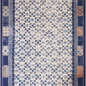Blue and cream low-pile rug with geometric patterns and a complex border featuring terracotta accents.